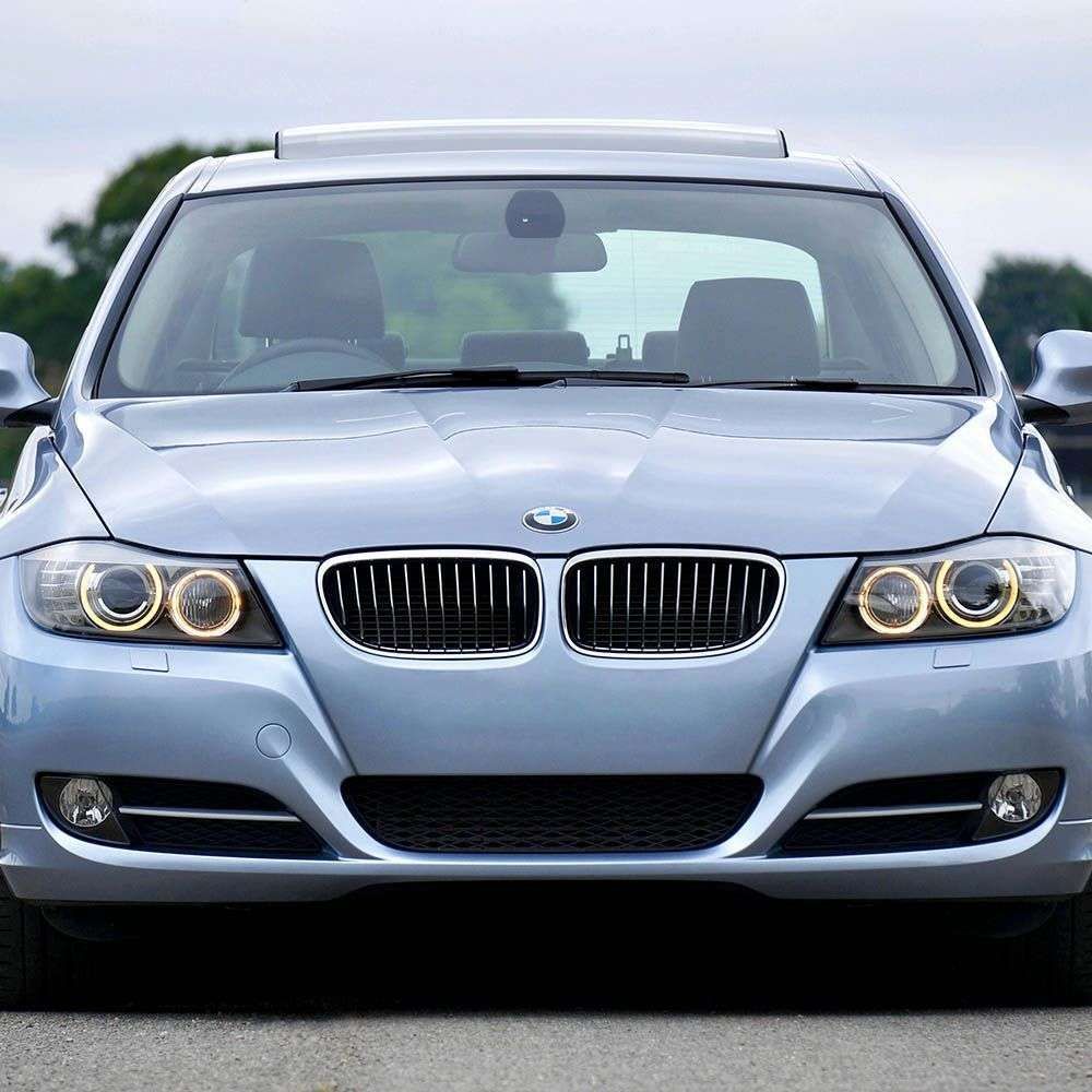 Silver BMW with polished windshield prepared after scratch treatment service.