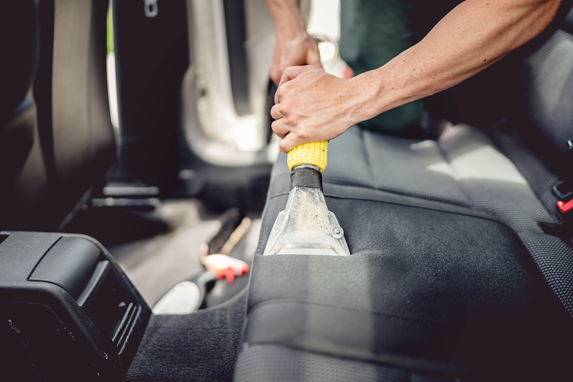 A professional technician cleaning vomit out of a car in Washington D.C.