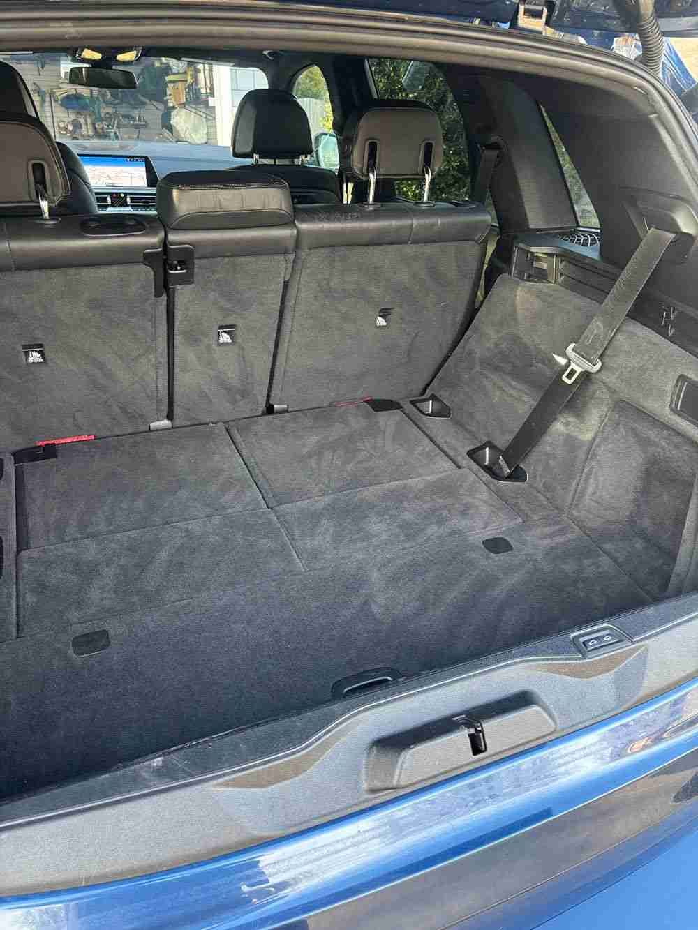 Rear vehicle interior showing trunk space targeted for odor neutralization.