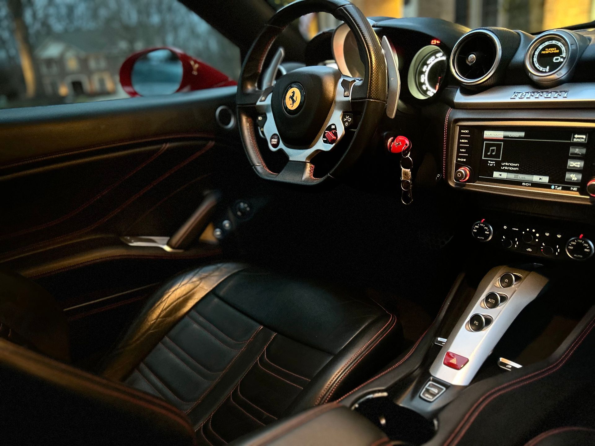 Front detail of a classic round headlight with chrome surround on a polished white exotic car.