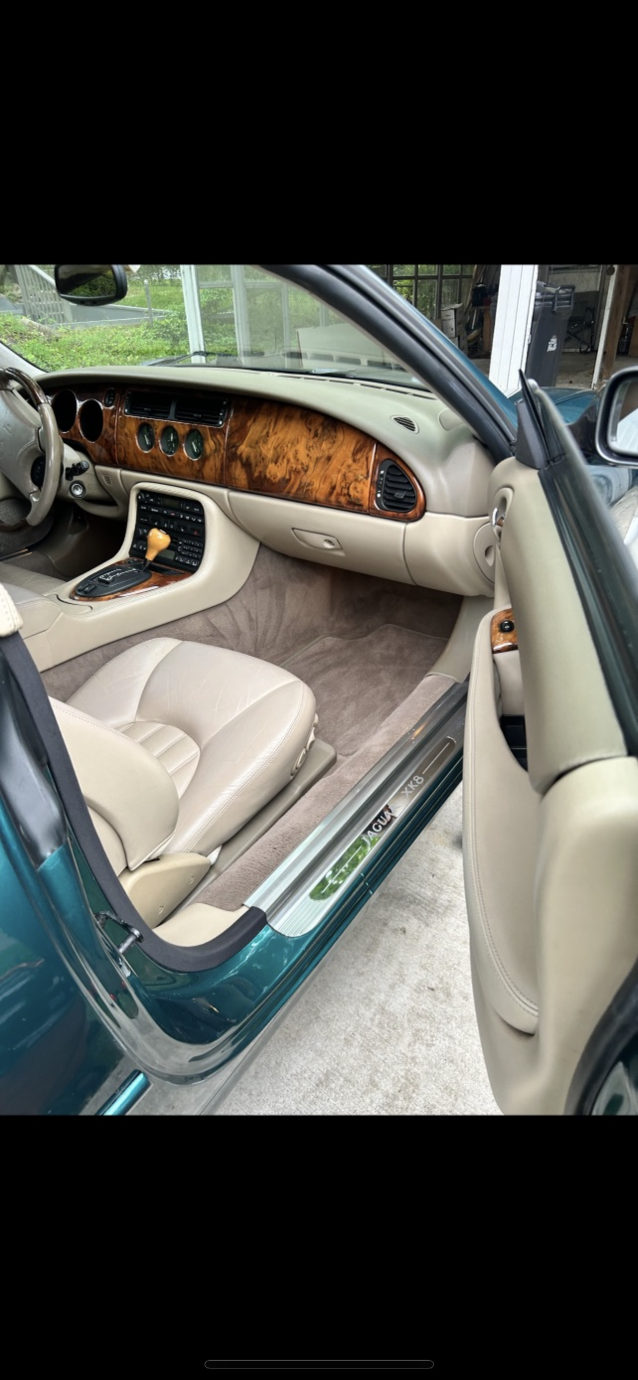 Front cabin of a sedan after interior detailing, with vacuumed carpets, conditioned leather, and a clean dashboard.