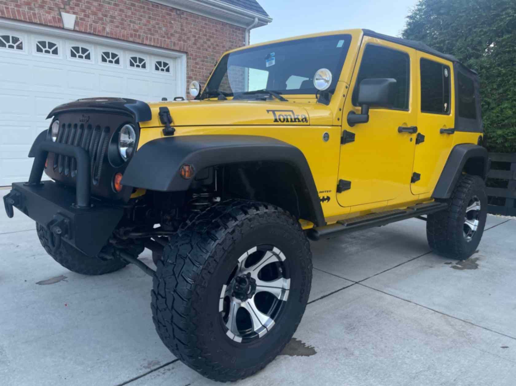 Yellow Jeep Wrangler Unlimited JK in a driveway after full detailing