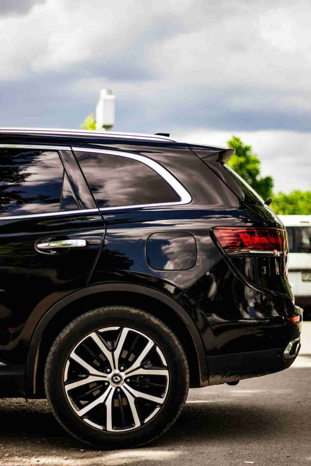 Black SUV side panel reflecting sky after professional detailing.