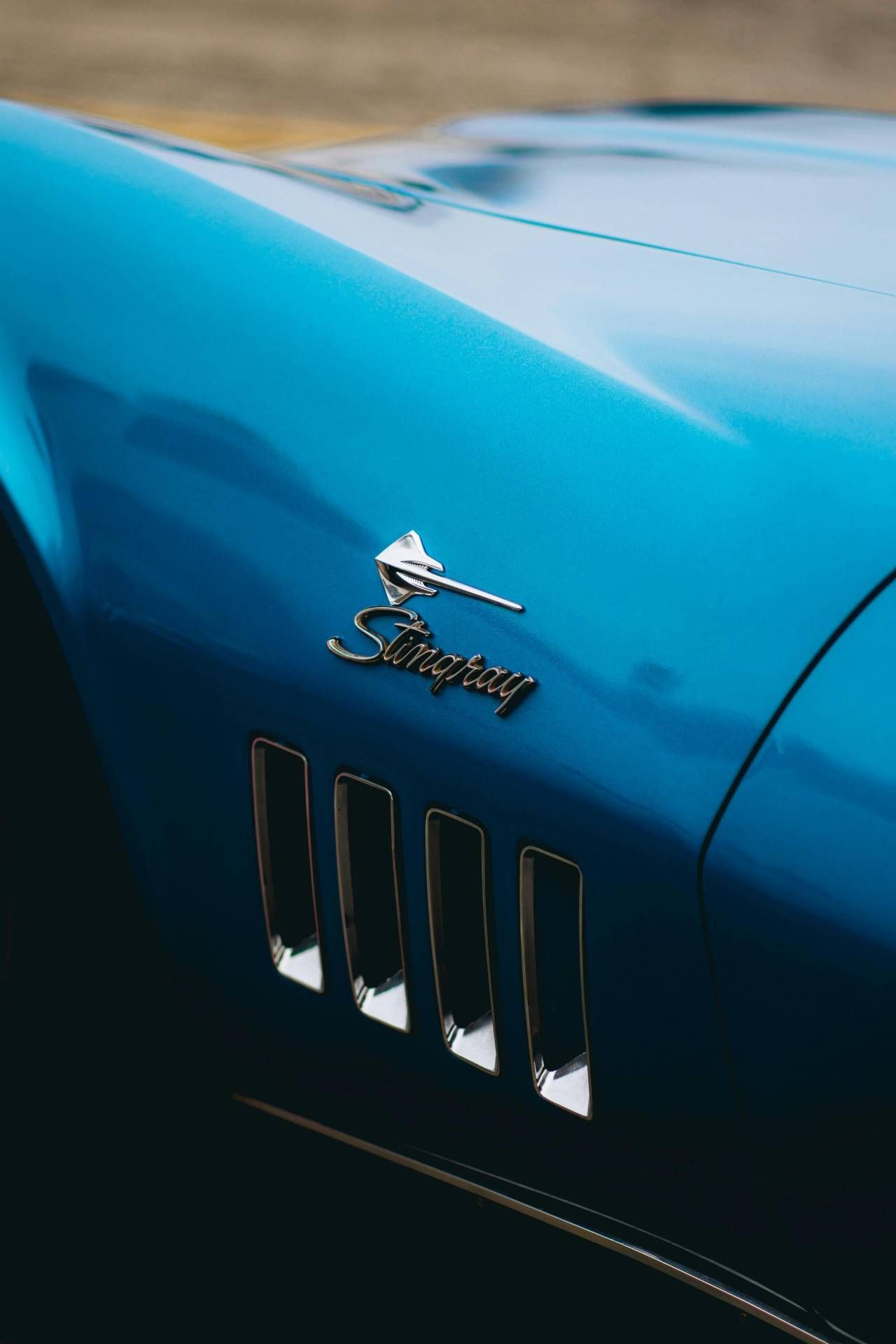 Close-up of a classic blue Corvette Stingray with polished paint finish after paint correction.