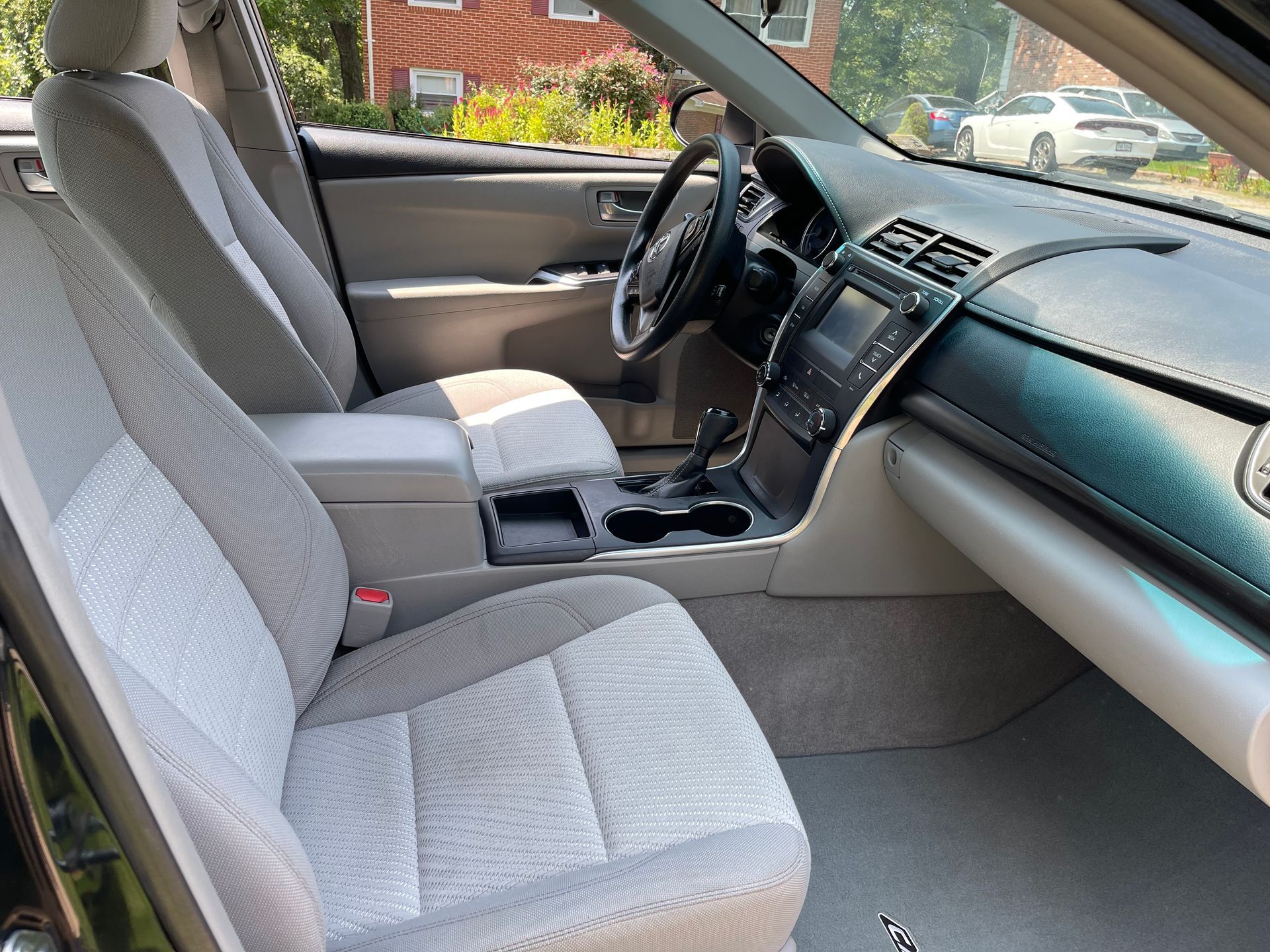 Front seat of an SUV post-detail, with shampooed upholstery, crumb-free mats, and organized seat pockets for passengers.