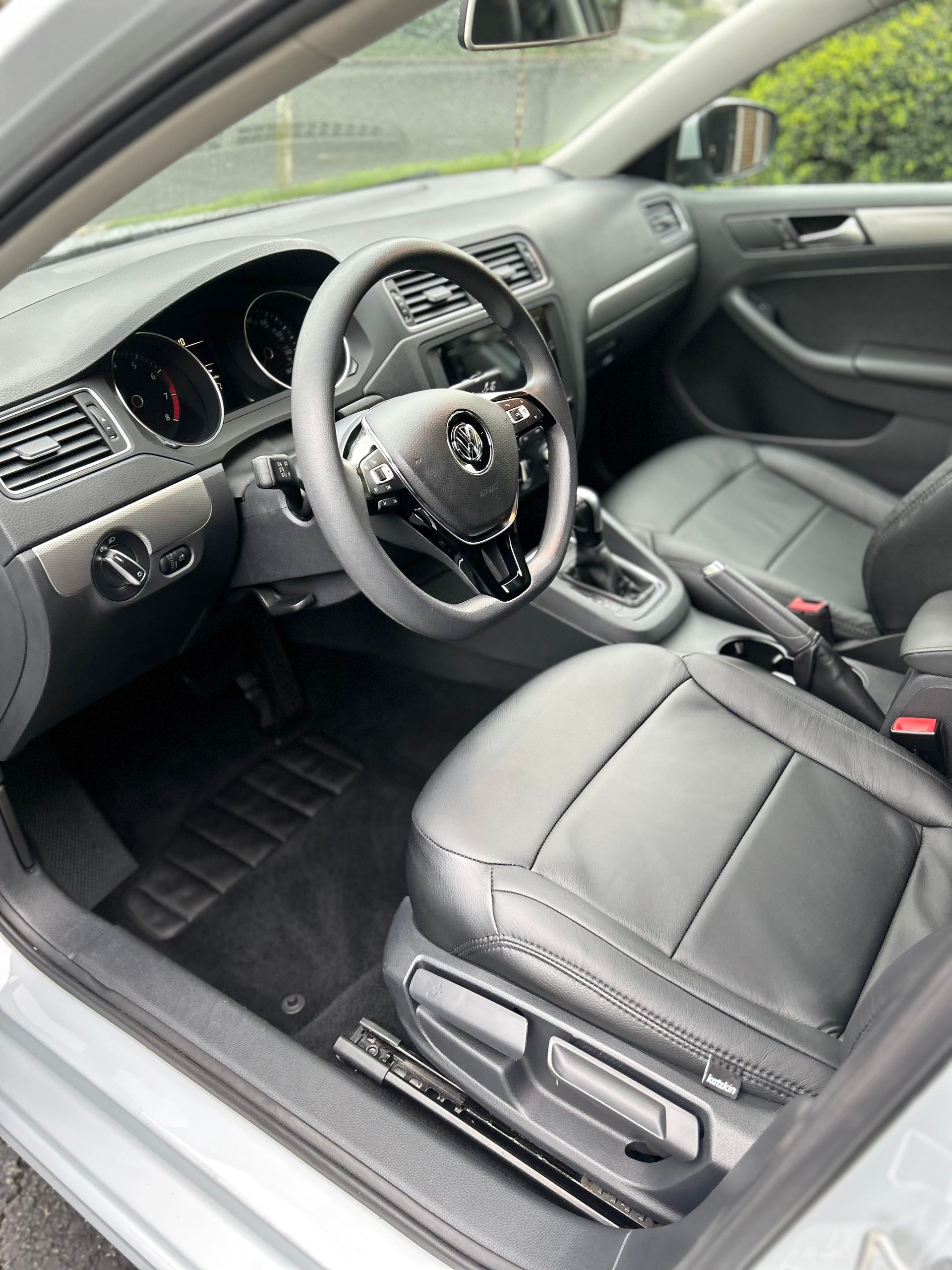Car's rear interior with black leather seats, one folded forward, revealing the floor for a comprehensive bio-cleaning.
