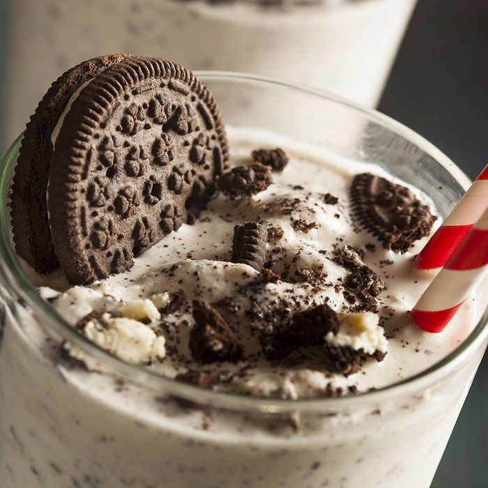a close up of a milkshake with oreos and straws