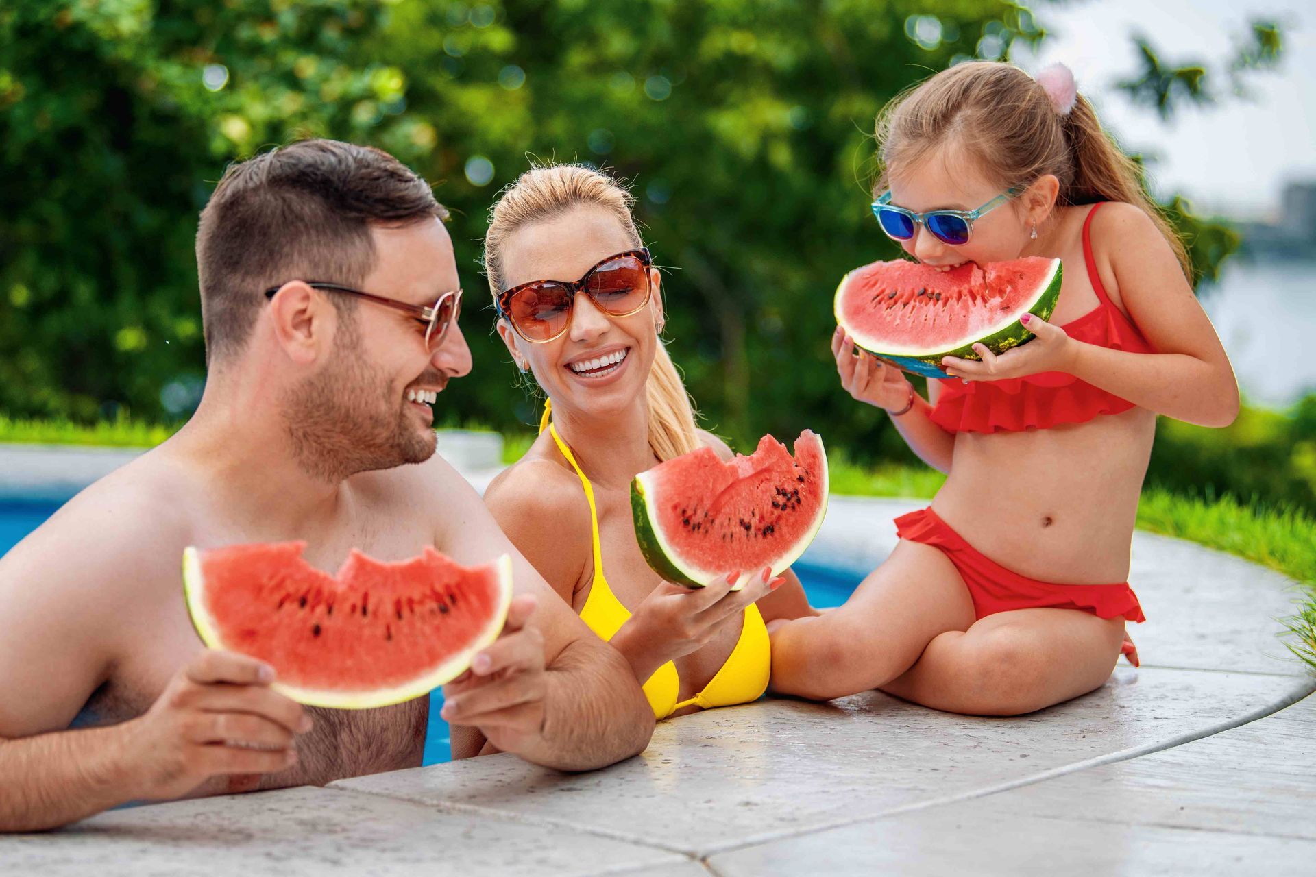 A family in their pool eating watermelons