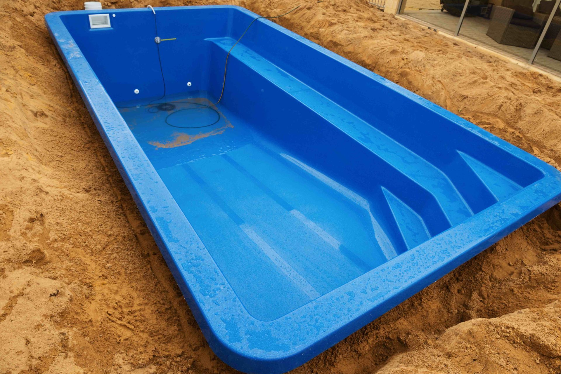 A fiberglass pool halfway installed in the ground