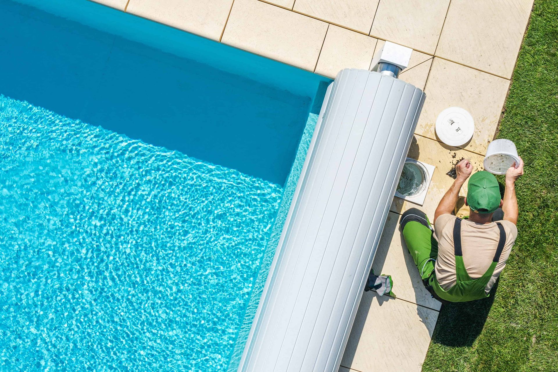 A Garland's Pool Professionals worker on the side of a pool