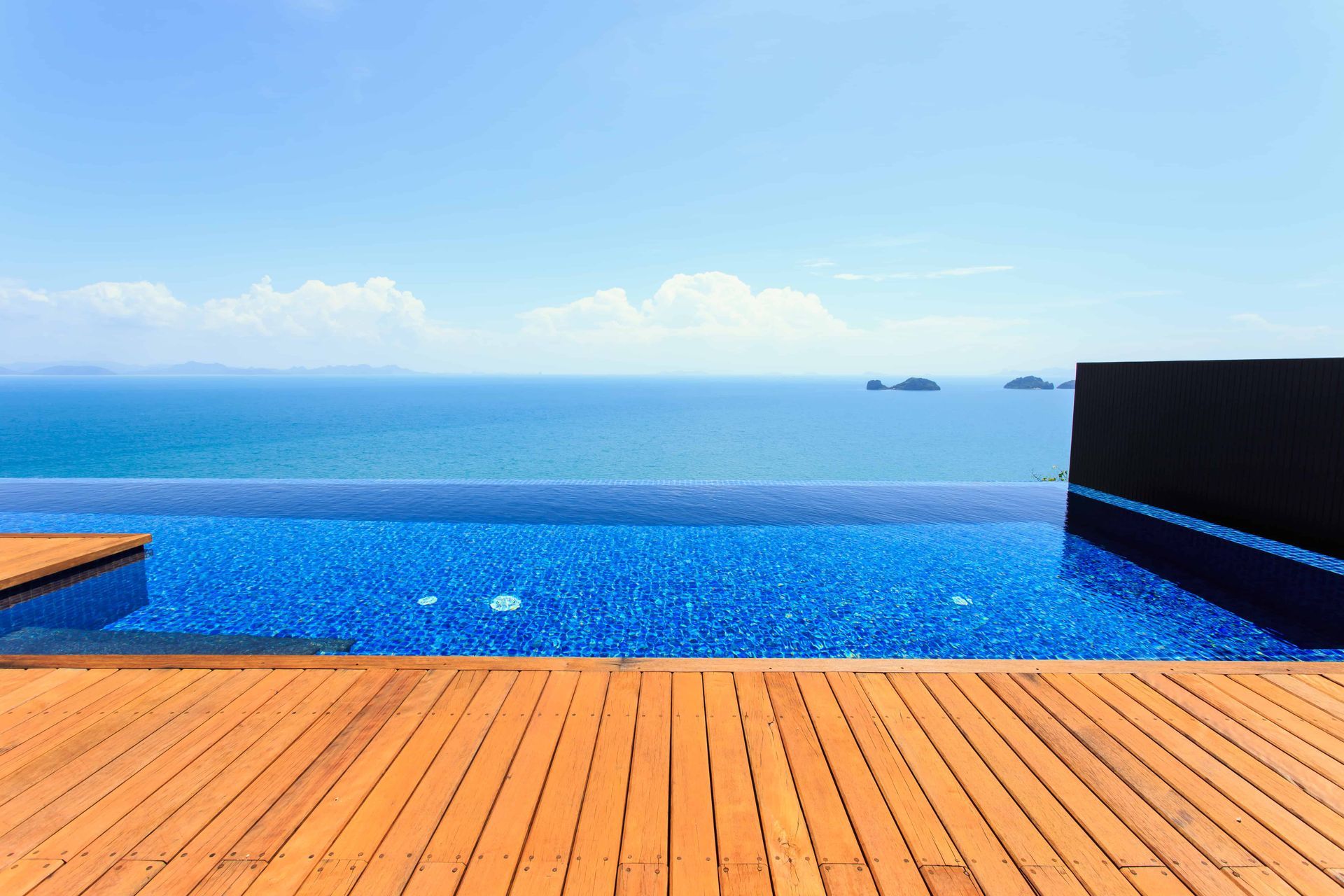 An infinity pool with a wooden deck