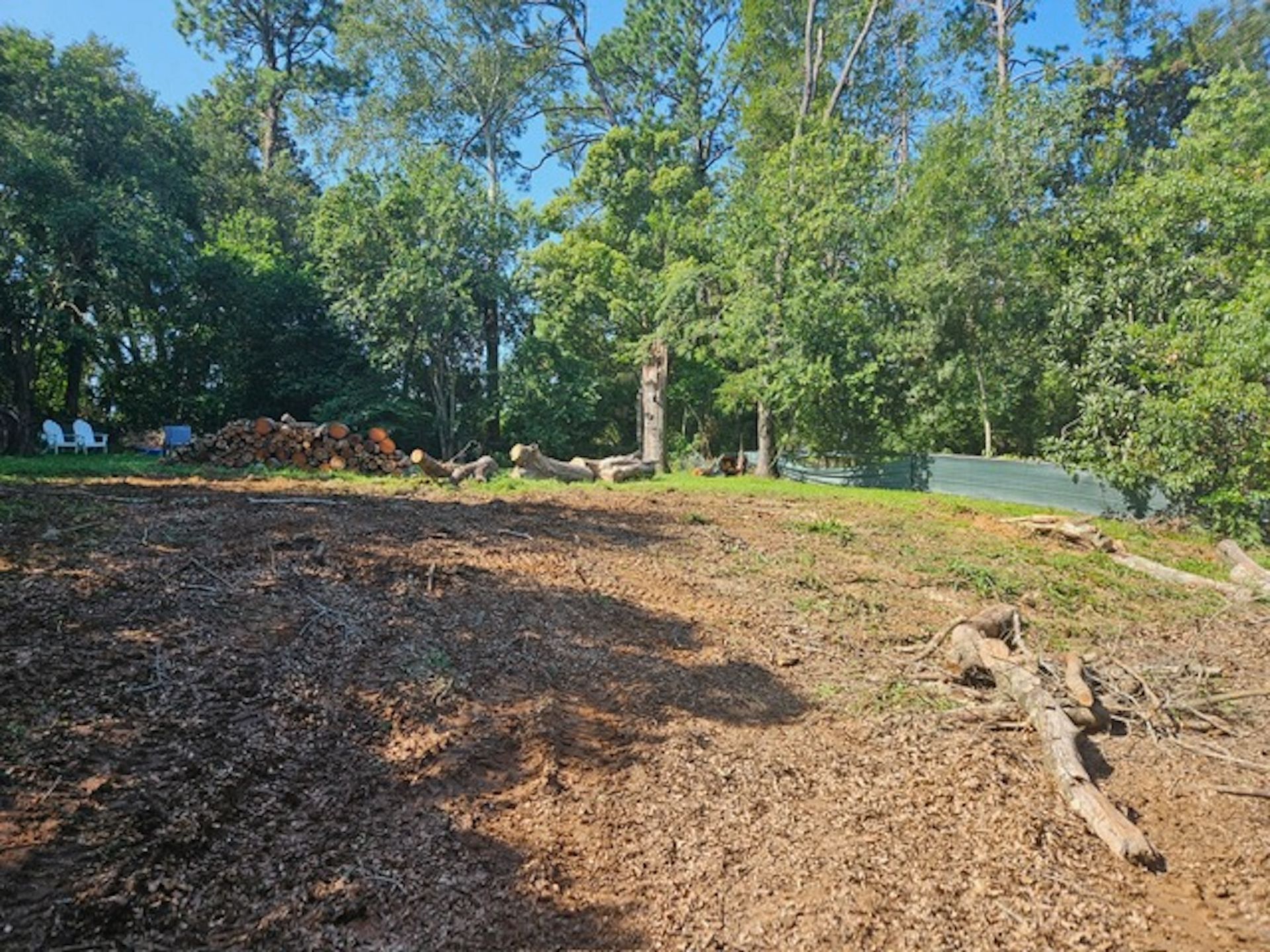 There is a lot of dirt in the middle of a field with trees in the background.