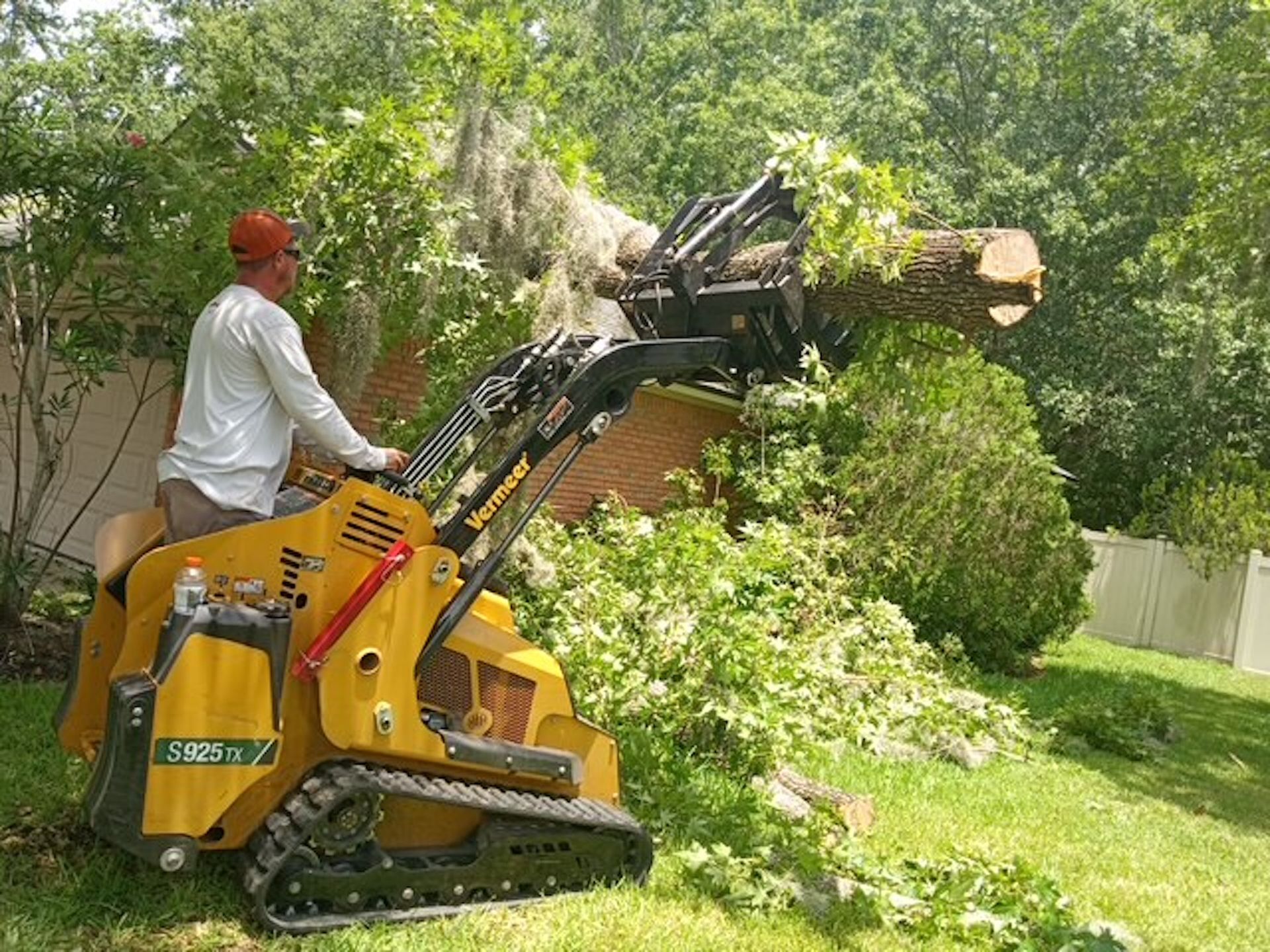 A man is using a machine to remove a tree stump from a yard.