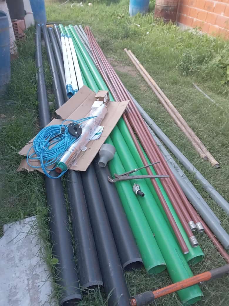 Un montón de tubos están apilados uno encima del otro en el césped.