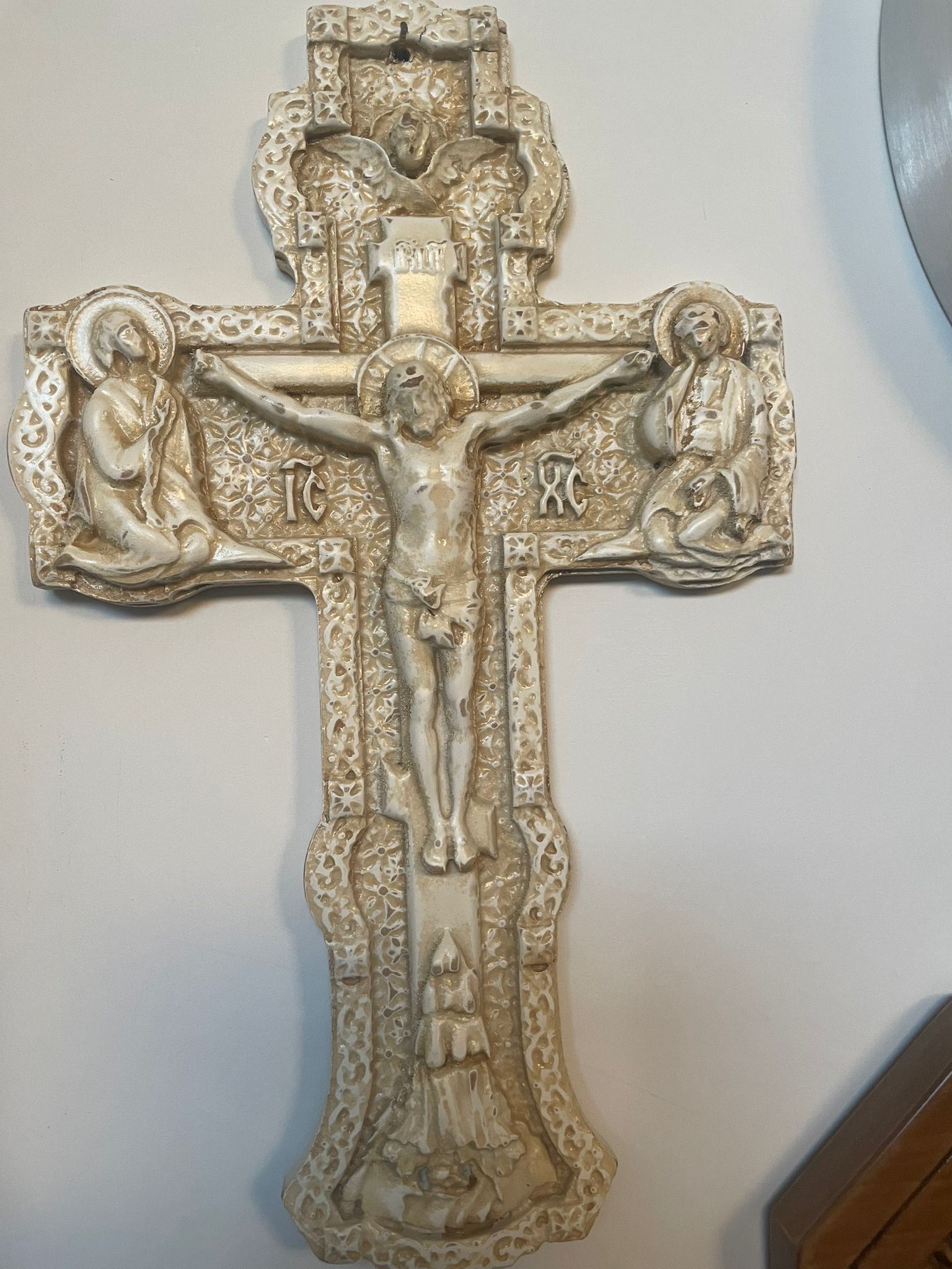 Una croce con Gesù sopra è su un muro bianco