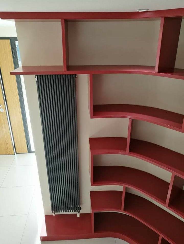 Una stanza con libreria rossa in legno su misura