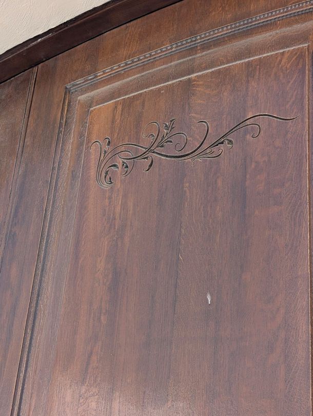 Primo piano di una porta di legno con un disegno floreale.