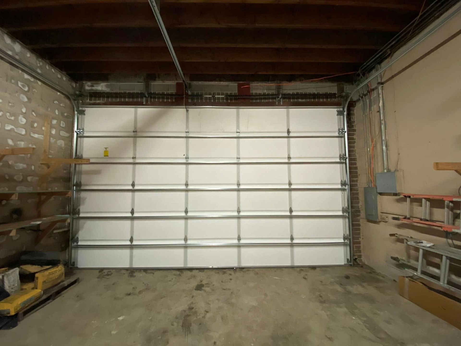 An empty garage with a large white garage door.