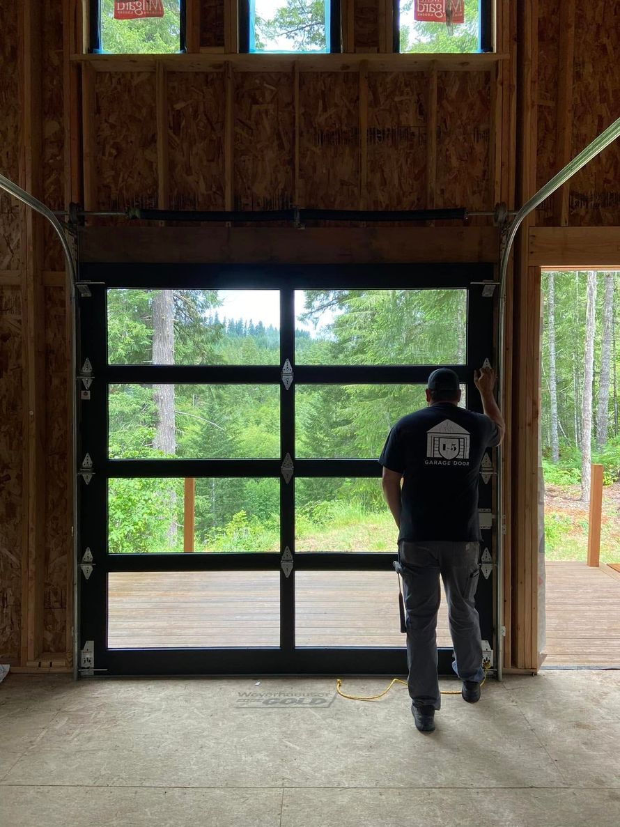 A man is standing in front of a garage door.