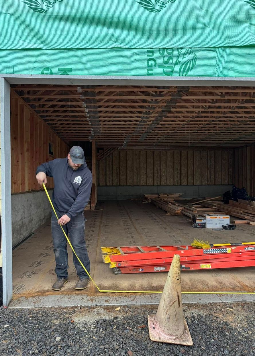 A man is measuring a garage door with a tape measure.