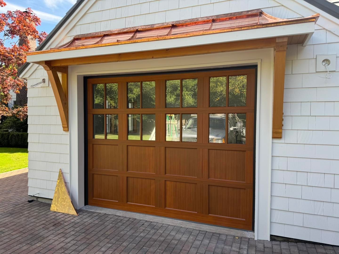 A garage with a wooden door and a copper roof