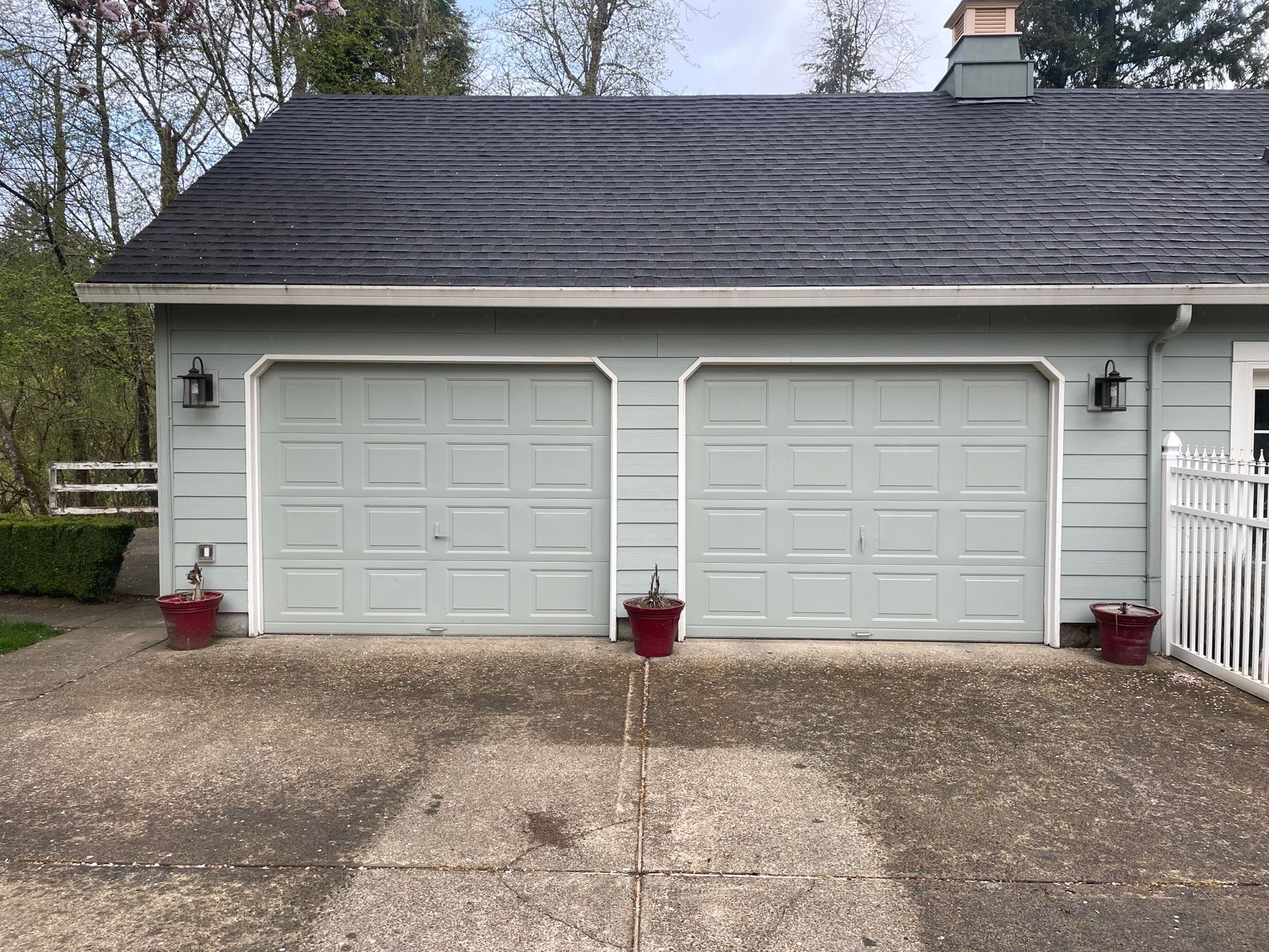 A garage with two garage doors and a black roof.