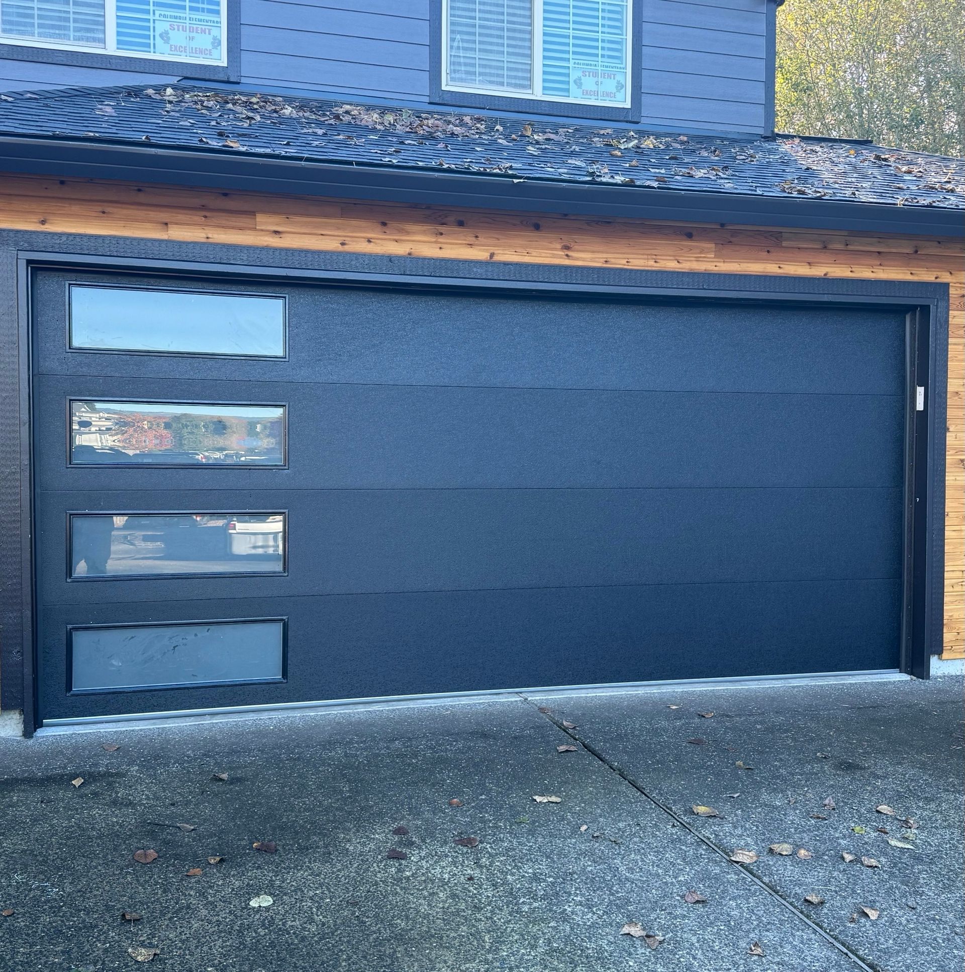 A ladder is sitting in a garage next to a garage door.