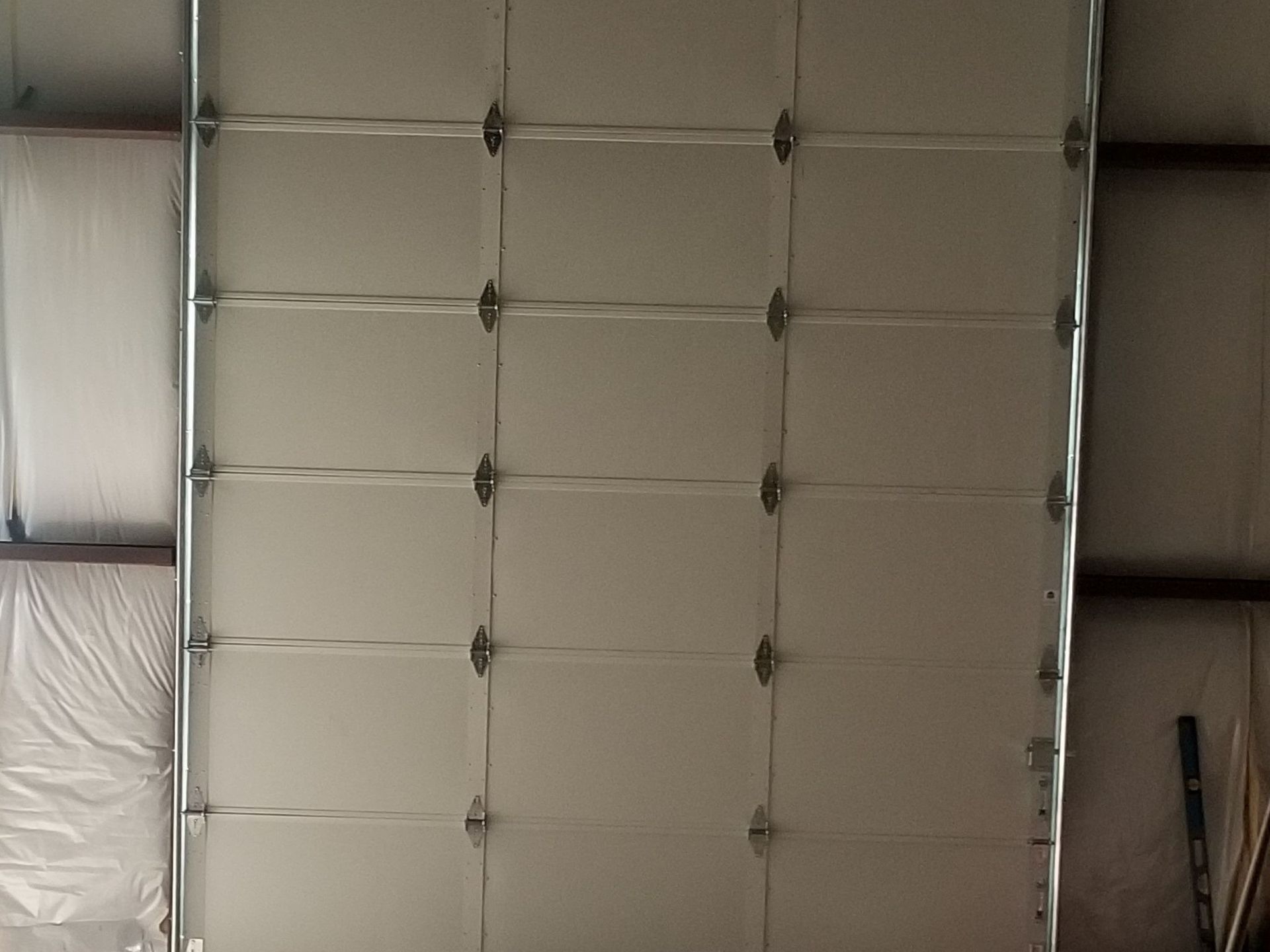 Closed, Insulated white garage door inside a building.