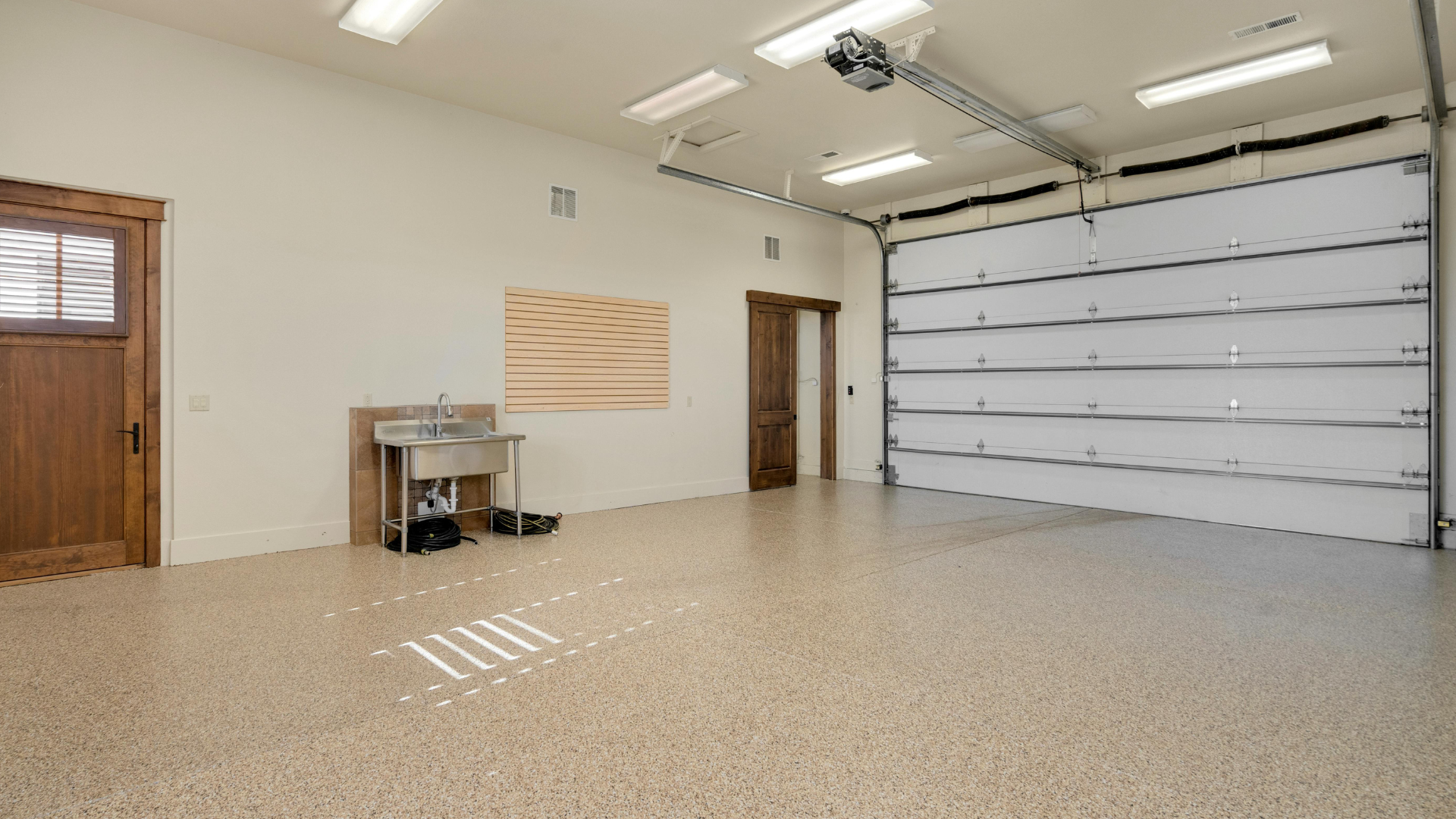 An empty garage with a sink and a garage door.