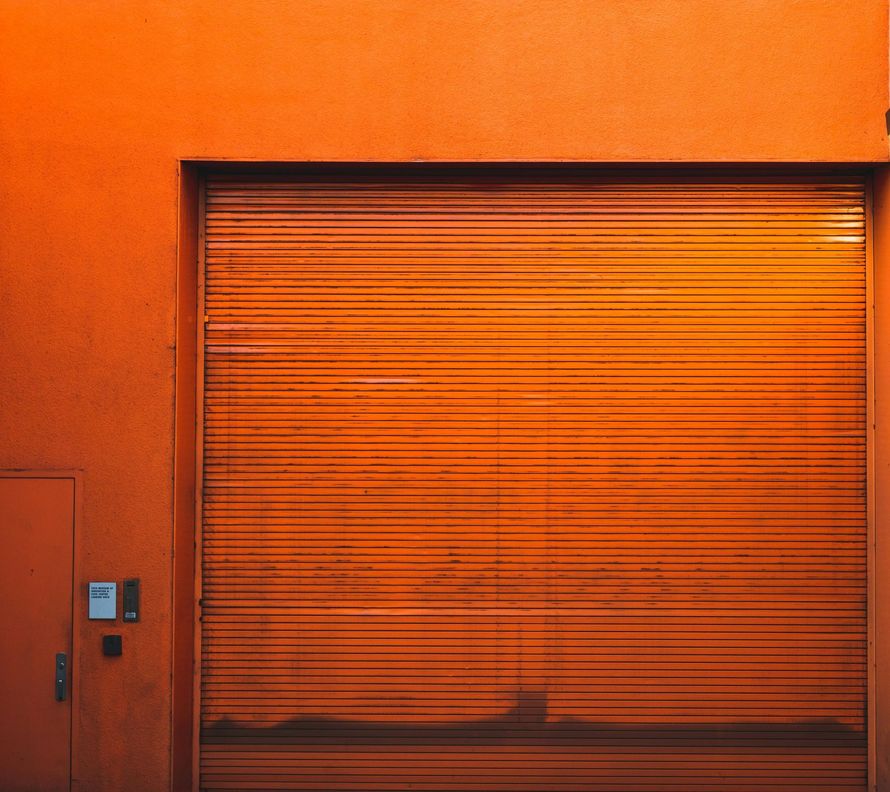 A close up of an orange garage door on an orange building.