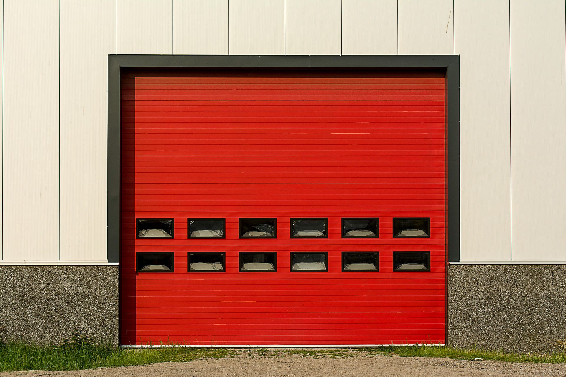 A red garage door is on the side of a building.