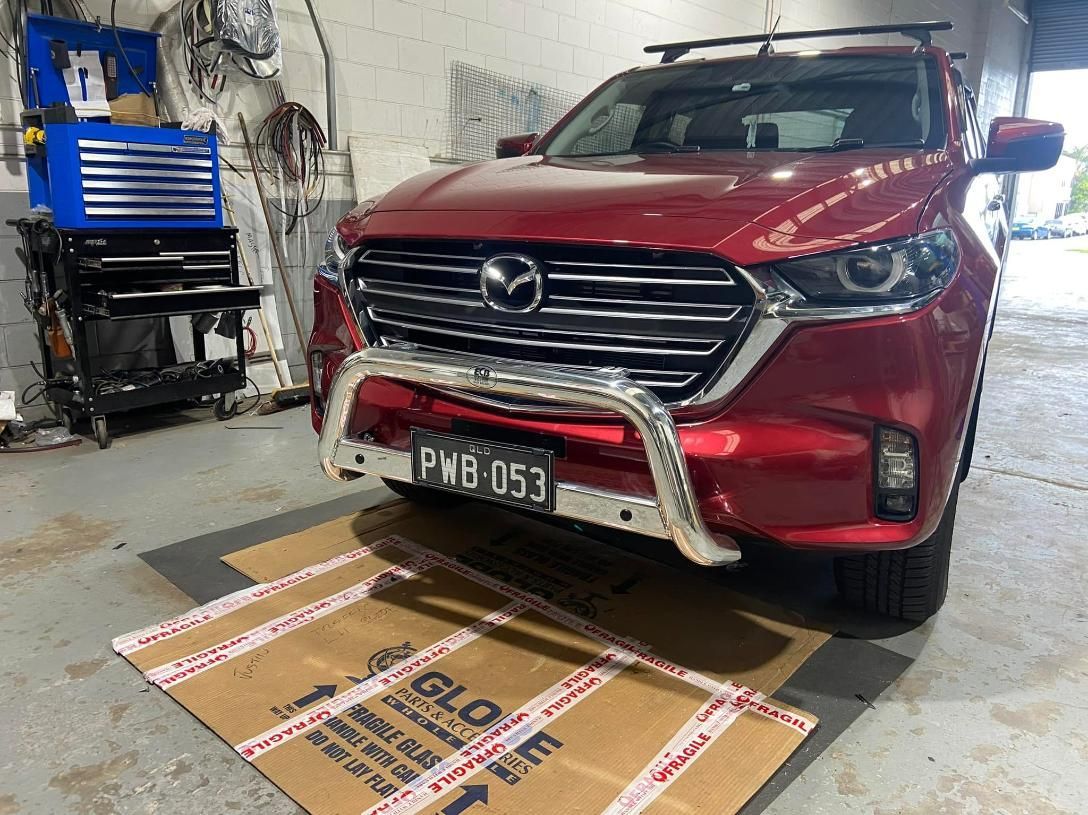 Red Mazda Truck With Chrome Bull Bar in a Garage — Motor Accessories Direct In Robina, QLD