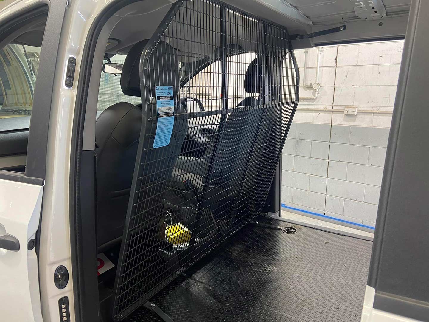 The Inside of A White Van with A Cage Between the Seats — Motor Accessories Direct In Tweed Heads South, NSW