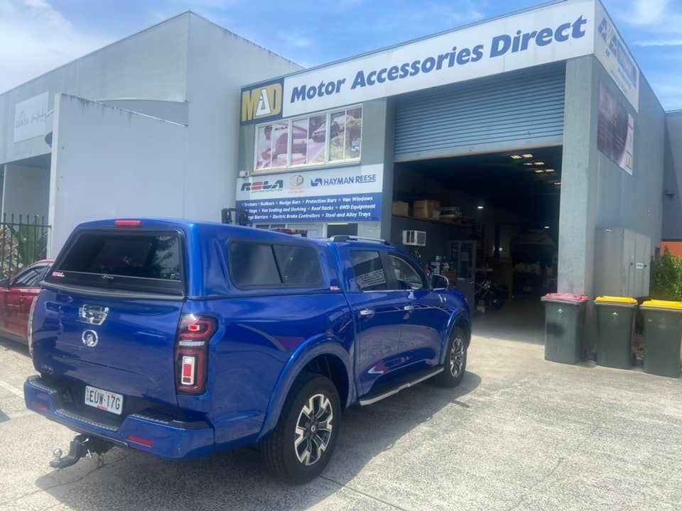 Blue Pickup Truck With a Canopy Parked in Front of Motor Accessories Direct Shop — Motor Accessories Direct In Robina, QLD