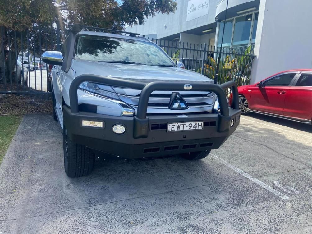 Gray Mitsubishi Pickup Truck With Black Bull Bar Parked Near a Building — Motor Accessories Direct In Byron Bay, QLD