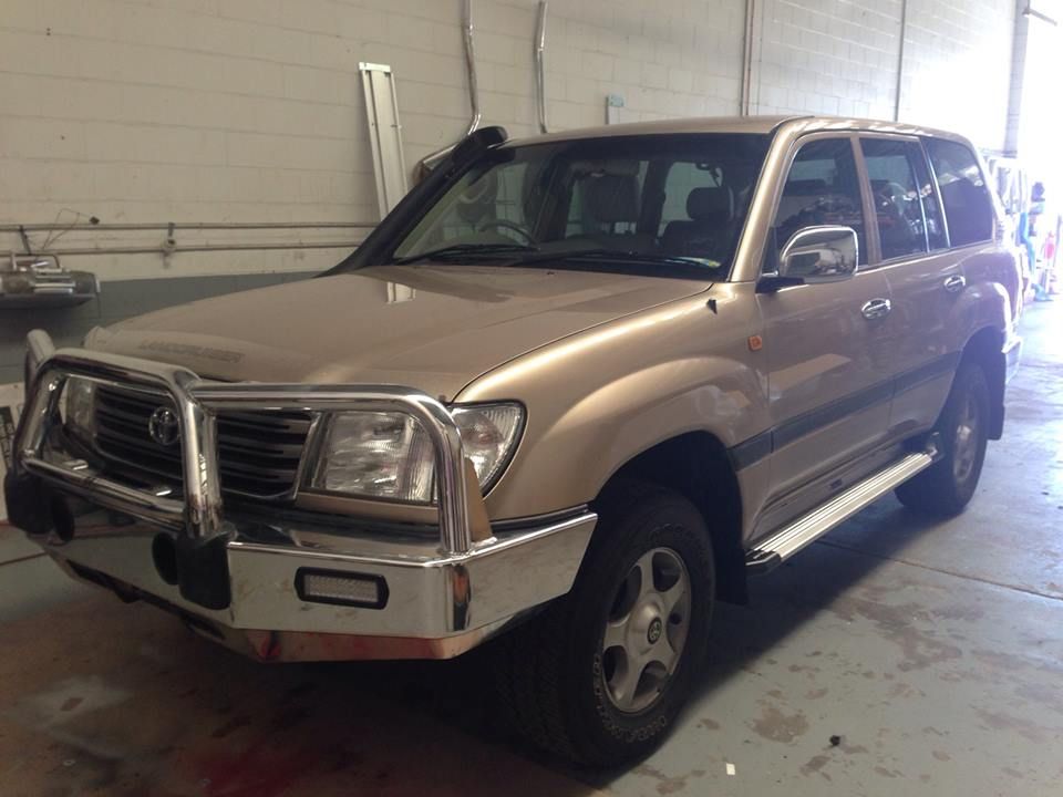 Gold Toyota Land Cruiser SUV With a Chrome Bull Bar, in a Garage — Motor Accessories Direct In Byron Bay, QLD