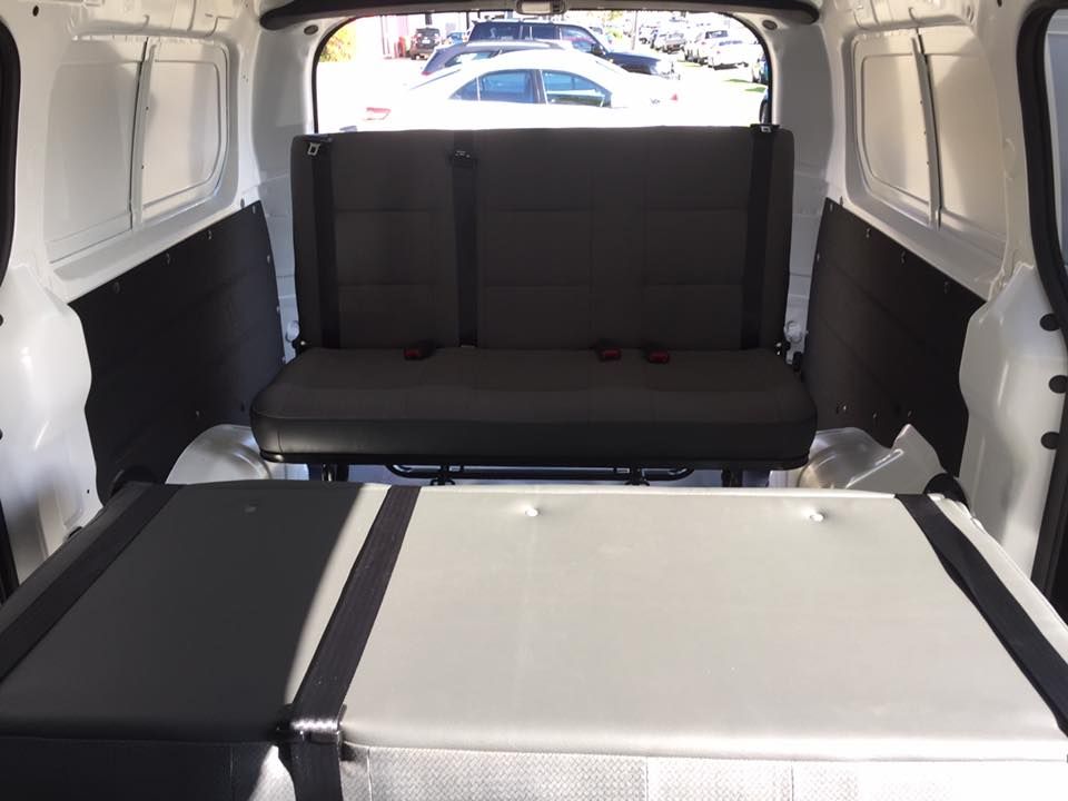 Interior of a White Cargo Van With a Fold-down Bench Seat and a Bed — Motor Accessories Direct In Southport, QLD