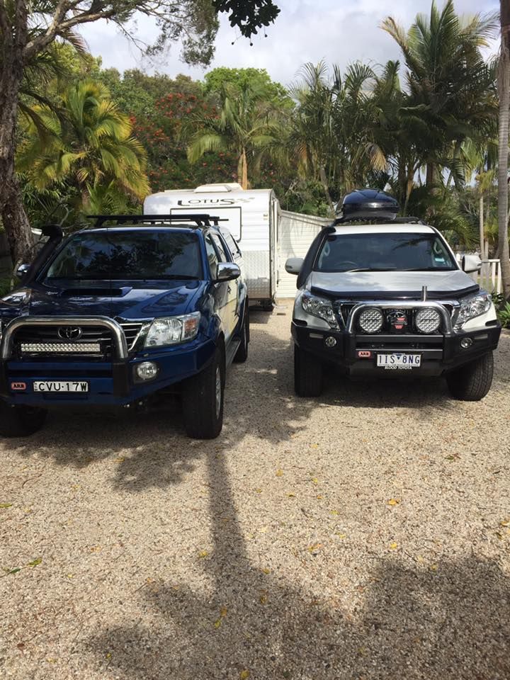 Two 4x4 Trucks Towing a Caravan on a Gravel Driveway — Motor Accessories Direct In Tweed Heads South, NSW