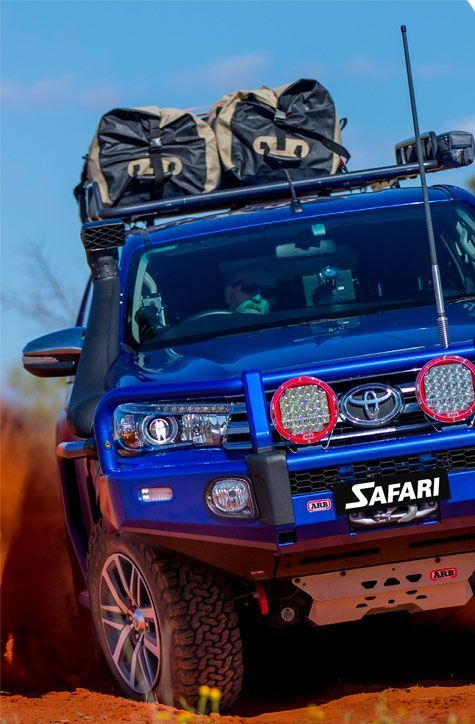 A Blue Toyota Hilux Is Driving Through the Dirt — Motor Accessories Direct In Tweed Heads South, NSW