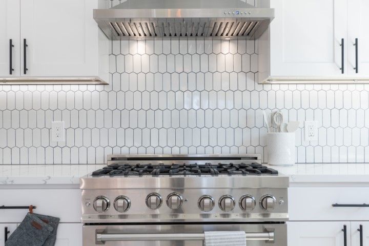 White kitchen with quartz countertops and white tile wall backsplash