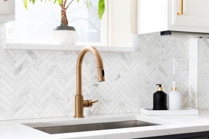 White limestone countertop with white patterned tile wall backsplash