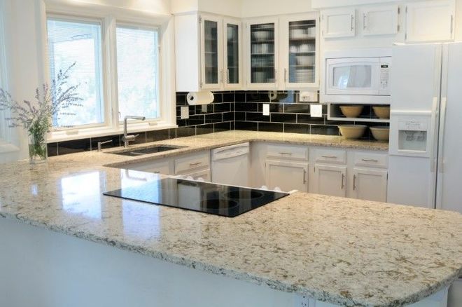 White kitchen with white cabinets with glass doors. White granite countertops