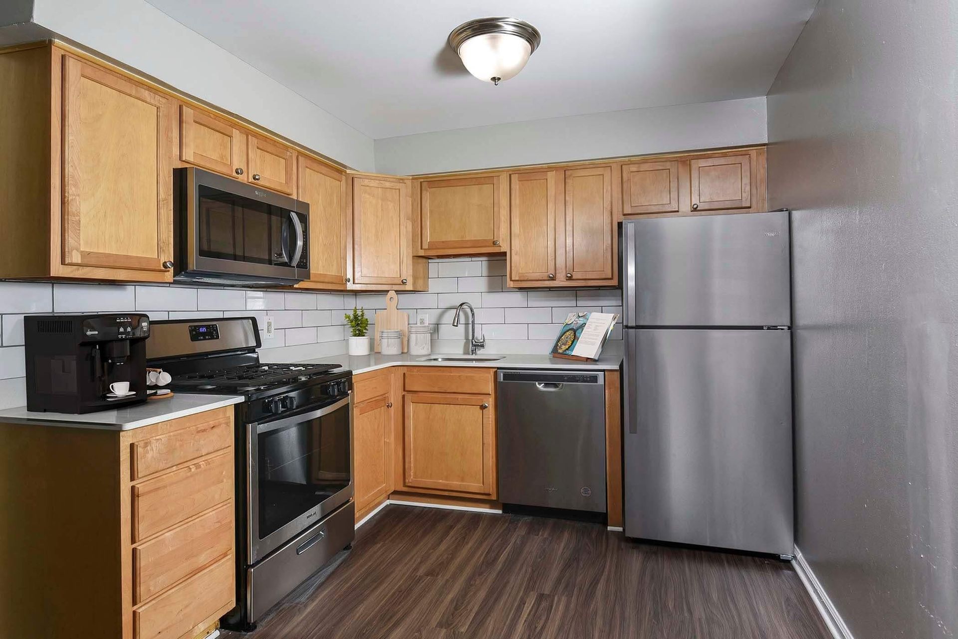 Kitchen with wooden cabinets, stainless steel appliances, and a white subway tile backsplash.