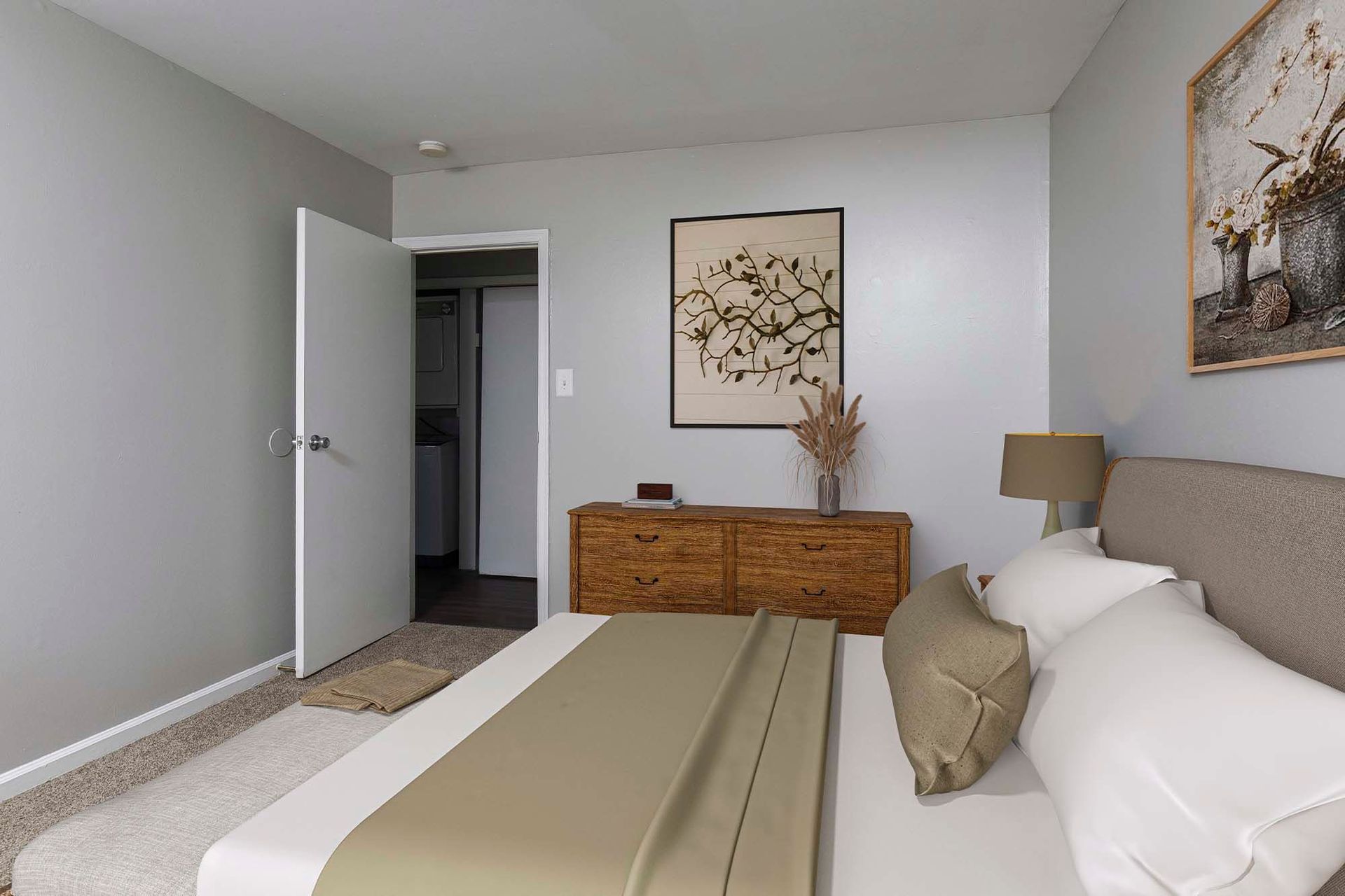 Bedroom in an apartment with a bed, dresser, and framed art on the wall.