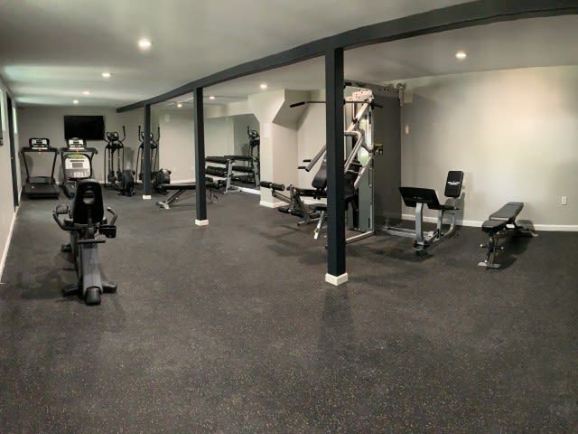 Indoor community gym with cardio machines and weight equipment in a spacious room.