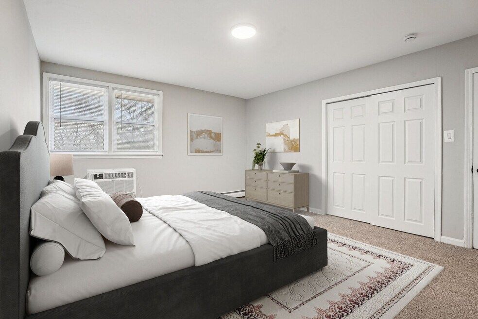 Bedroom with bed, dresser, window, and closet. Gray and white color scheme.