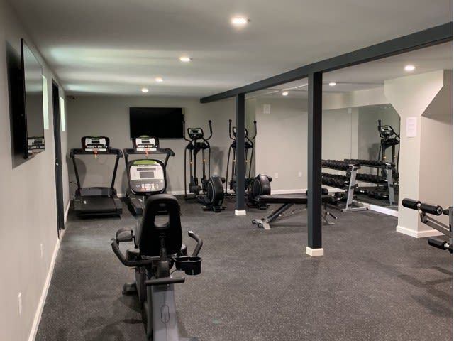 Interior view of a resident fitness center with treadmills, ellipticals, bikes, and free weights.