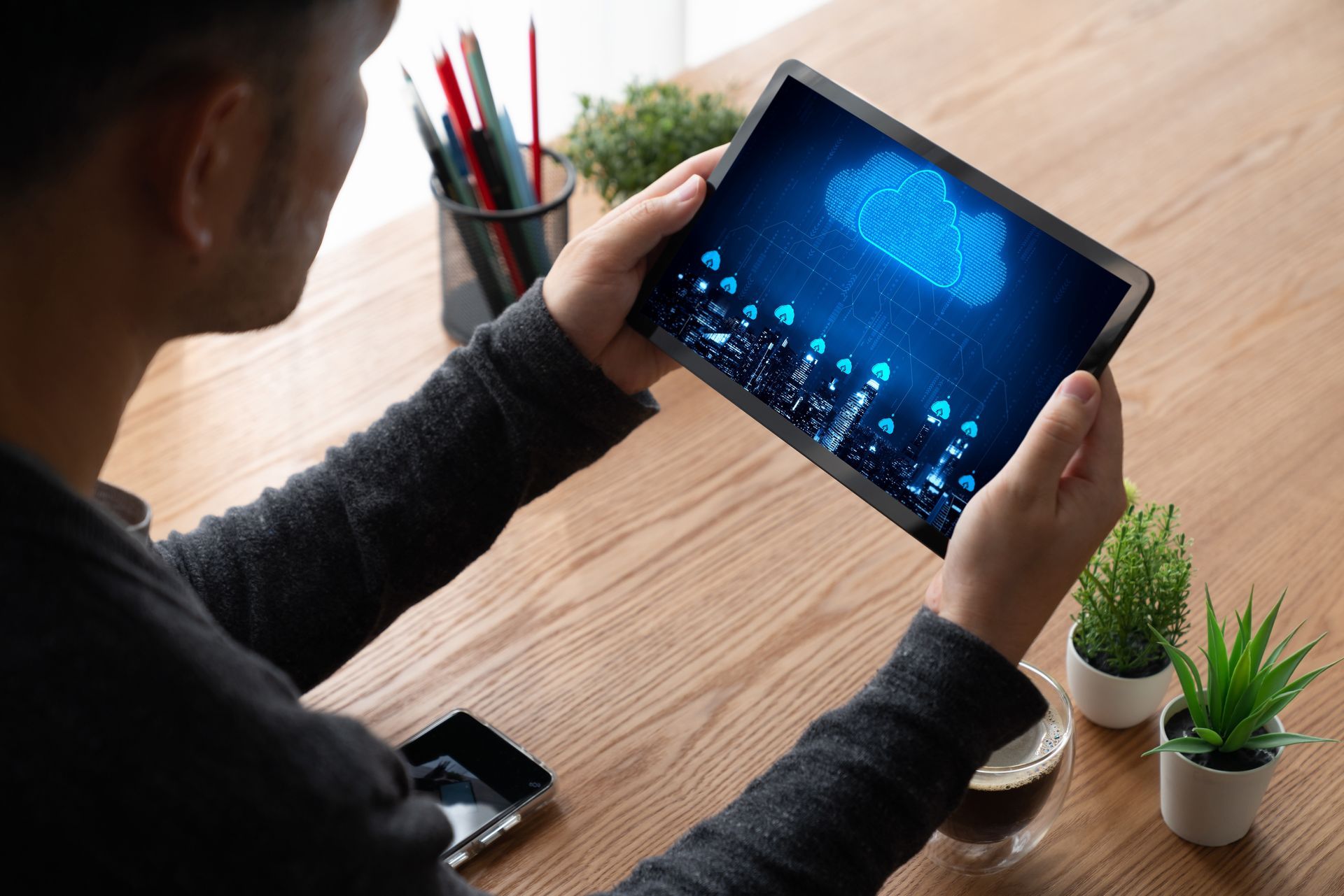Een man houdt een tablet vast met een wolk op het scherm.