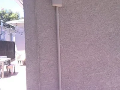 A gray wall with a white pipe on it