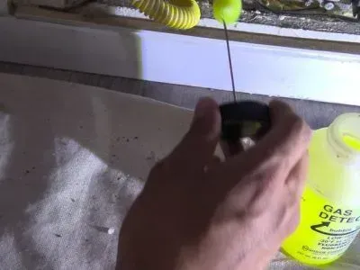 A person is holding a yellow bottle that says drain cleaner